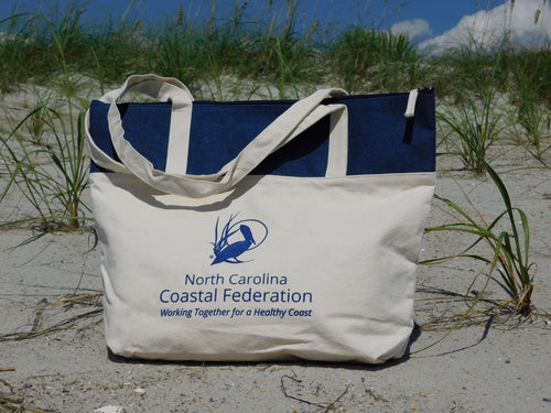 Tote bag with North Carolina Coastal Federation logo on a sandy beach