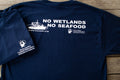 Navy blue t-shirt with white text and graphics on a wooden surface
